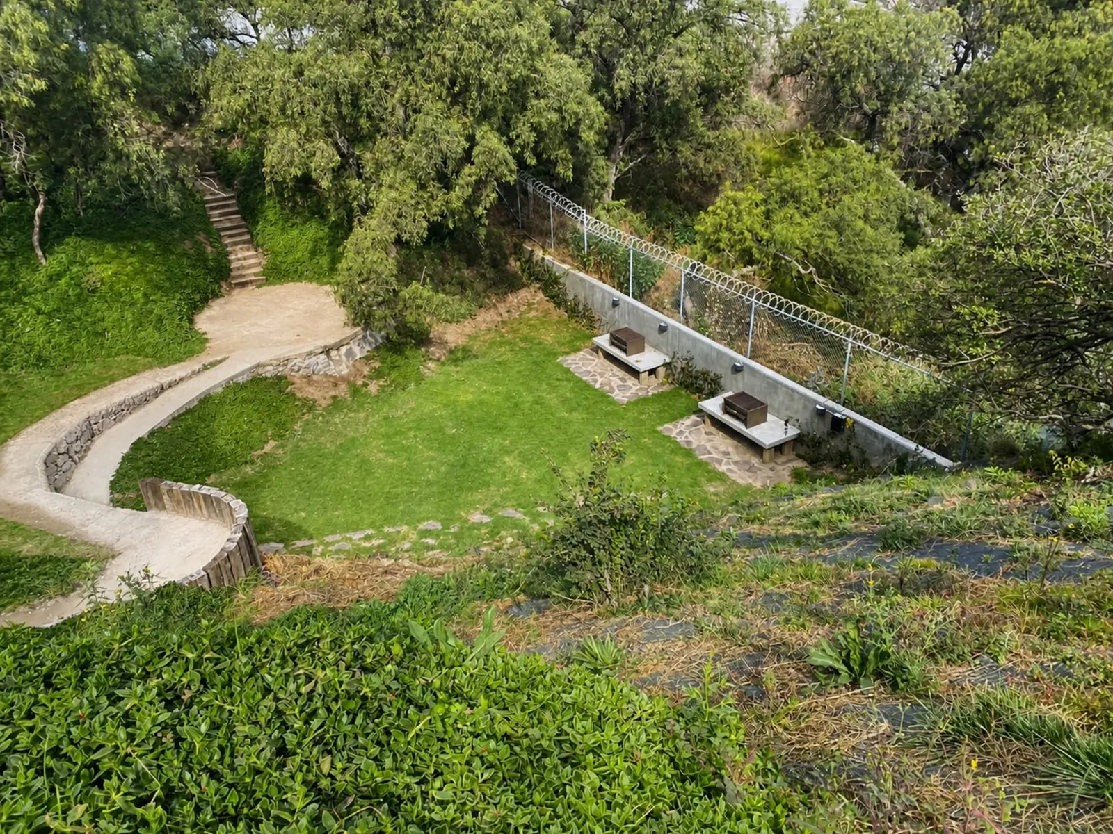 Jardín común con asadores y andador empedrado