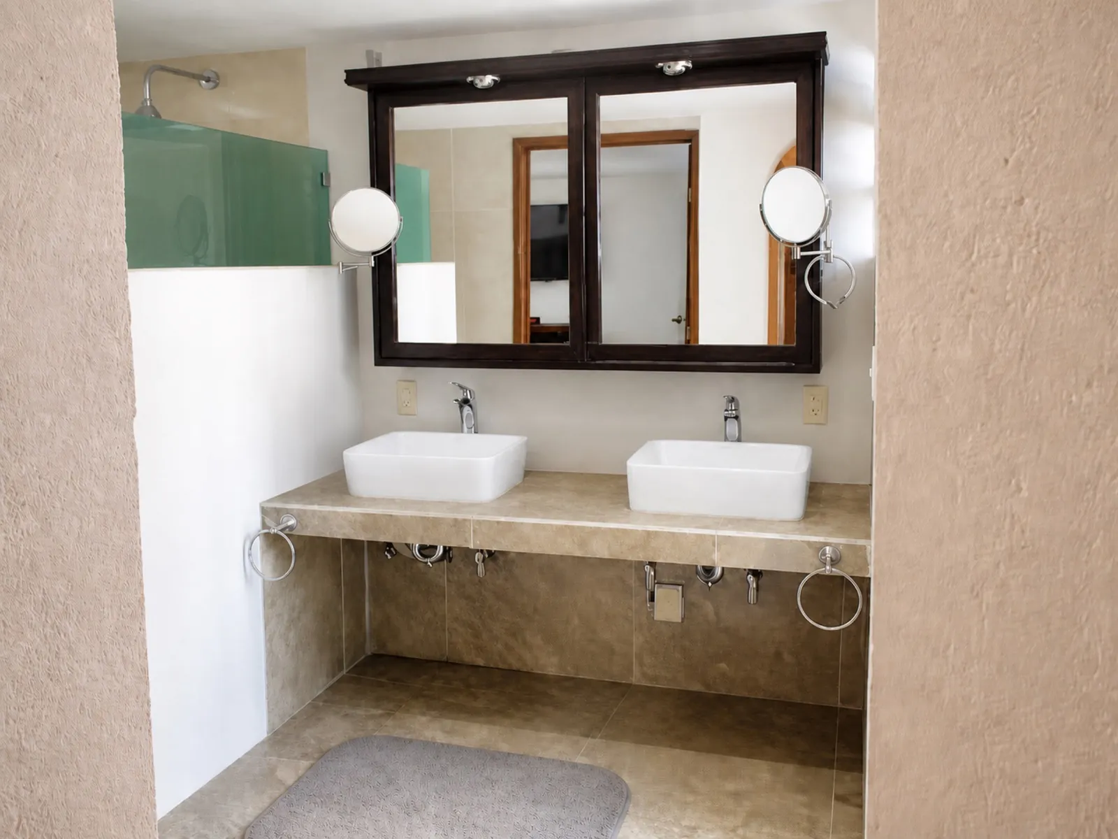 Baño con doble lavabo y espejo de madera